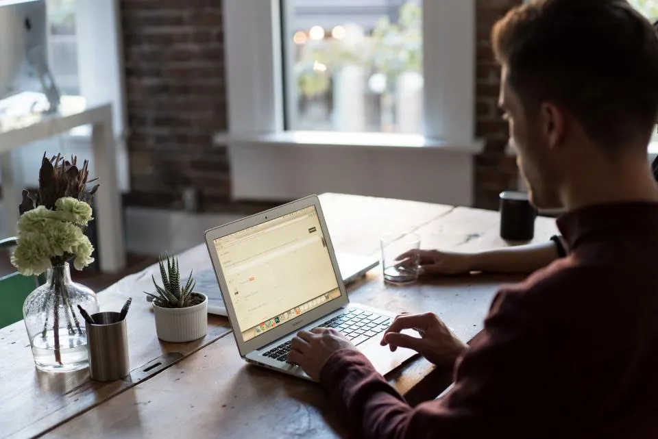 Business owner working on a laptop at a bright desk